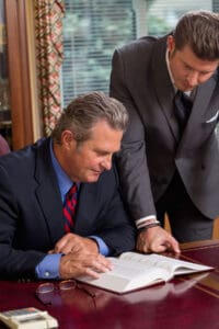 Richard Breen and Connor Breen reviewing legal doctrine in office.