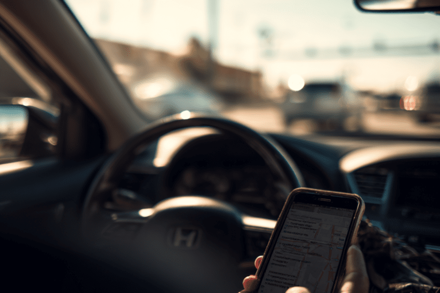 Driver using phone while driving in Louisville intersection, illustrating distracted driving accident case for Louisville car accident lawyer