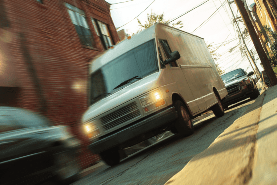 Delivery truck driving through narrow Louisville street, illustrating cases handled by a Louisville truck accident lawyer